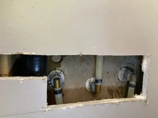 back of the shower, where the pipes attach