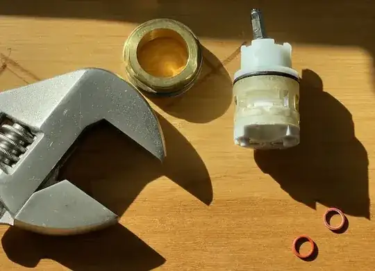 crescent wrench, brass nut, and cartridge with o-rings