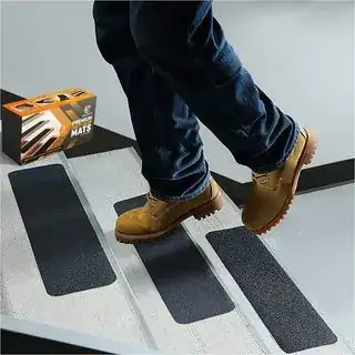 person in boots walking up stairs with grip tape