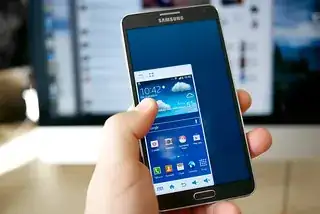 smartphone where the entire screen contented is resized to 70% and moved to the lower left corner, making it easier to interact with everything with the left hand holding the phone