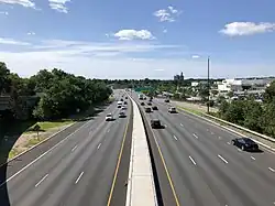 a wide road with many shops on both sides on a sunny day in Paramus
