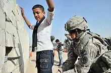 Image 23U.S. Army soldier searches an Iraqi boy, March 2011. (from History of Iraq)