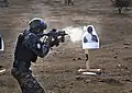 Member of the Haitian National Police firing a Galil ACE 21 at a target during critical task events training exercise in a simulated tactical environment