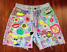 Image 26Acid washed jean shorts with grunge and hippie inspired DIY slogans and pictures. (from 1990s in fashion)