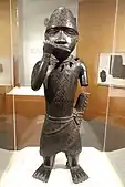 Figure of a horn blower; 1504–1550; copper alloy; 62.2 x 21.6 x 15.2&nbsp;cm (241⁄2 x 81⁄2 x 6 in.); Brooklyn Museum (New York City). Blowing a horn or flute with his right hand, his left arm is truncated. He also wears a netted cap with chevron design decorated with a feather