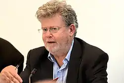 Milbank seated at a panel