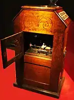 Reverse side of a Kinetophone, showing a wax cylinder phonograph driven by a belt