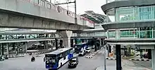 Jakarta MRT train, TransJakarta buses, and several private vehicles crossing the intersection near CSW-ASEAN TOD
