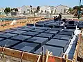 Wafflemat foundations like this one have covered over 25,000,000&nbsp;sq&nbsp;ft (2.3&nbsp;km2) of ground. They are built using void forms that allow the foundation to compensate for collapsible soils.