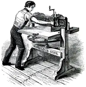 Cross-hatched image of a man working at a large bench, holding an attached tool against a clamped book.